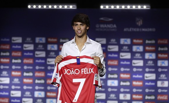 Atletico Madrid&#039;s new signing soccer player Joao Felix holds his new jersey as he poses for media during his official presentation at the Wanda Metropolitano Stadium in Madrid, Monday, July. 8, 2 ...