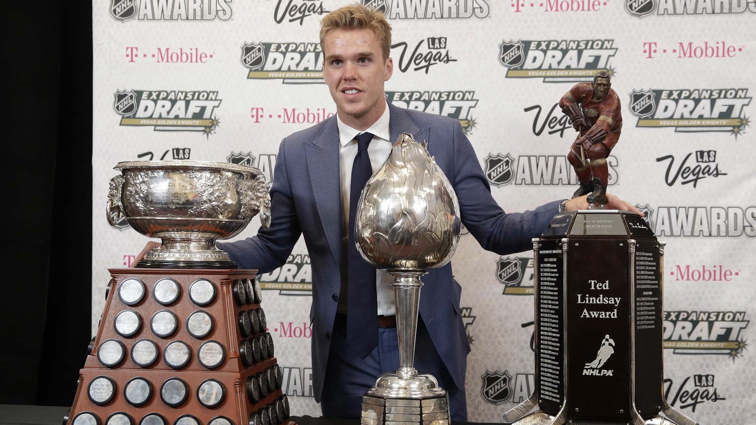 Connor McDavid of the Edmonton Oilers poses with the Art Ross Trophy, left, the Hart Memorial Trophy, center, and the Ted Lindsay Award after winning the honors during the NHL Awards, Wednesday, June  ...