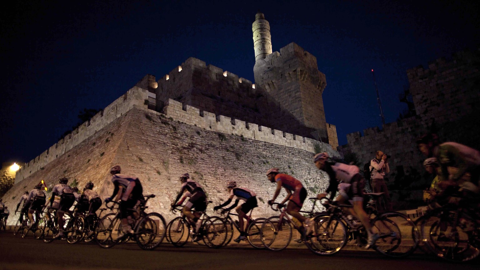 FILE - In this Dec. 6, 2011 file photo, cyclists from the Saxo Bank team ride past the walls of Jerusalem&#039;s Old City during a race. Israel is ready to finally get things underway this week with i ...