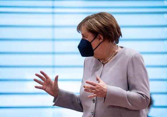 epa09256687 German Chancellor Angela Merkel wears a face mask and gestures prior to the weekly meeting of the German Federal cabinet in the conference hall of the Chancellery in Berlin, Germany, 09 Ju ...