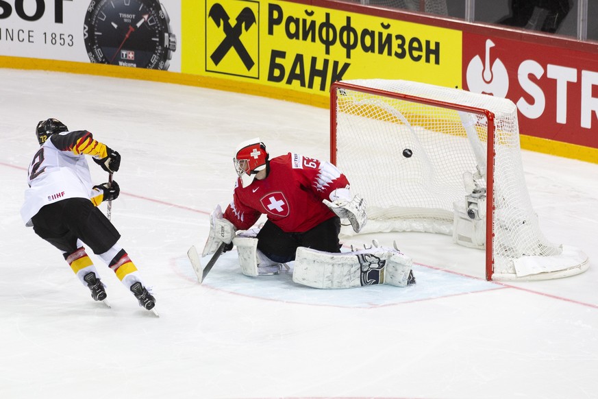 epa09245586 Germany&#039;s Dominik Kahun (L) scores a penalty against Swiss goalie Leonardo Genoni (R) during the shootout of the IIHF Ice Hockey World Championship 2021 quarter final game between Swi ...