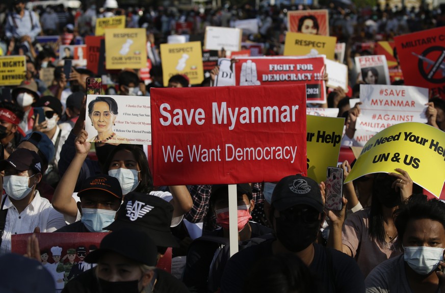 epa09014090 People holding posters and placards gather in front of police roadblocks near the headquarters of the National League for Democracy (NLD) party, led by detained Myanmar State Counsellor Au ...