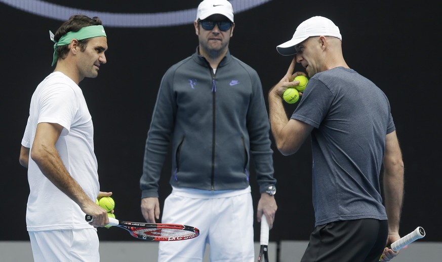 Switzerland&#039;s Roger Federer, left, talks with his coaches Ivan Ljubicic right, and Severin Luthi during a practice session ahead of the Australian Open tennis championships in Melbourne, Australi ...
