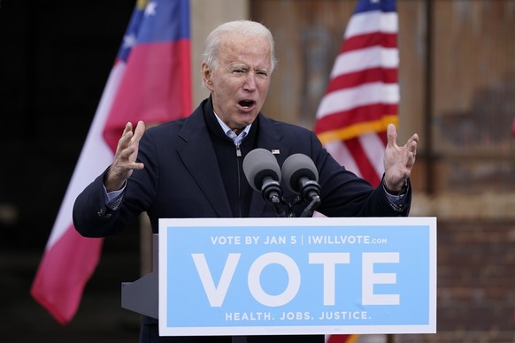 FILE - In this Tuesday, Dec. 15, 2020, file photo, President-elect Joe Biden speaks at a drive-in rally for Georgia Democratic candidates for U.S. Senate Raphael Warnock and Jon Ossoff, in Atlanta. Th ...