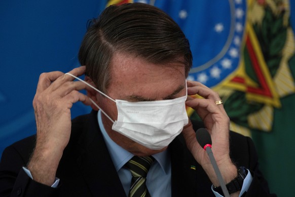 epa08305143 President of Brazil Jair Bolsonaro wears a face mask during a press conference on the measures taken by the government against the spread of the coronavirus, in Brasilia, Brazil, 18 March  ...