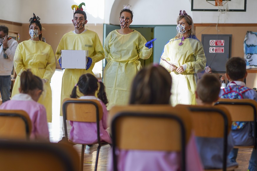 Medical personnel talk to children as they prepare them to receive non-invasive Covid 19 tests with chewing gum at the G.B. Grassi school, in Fiumicino, near Rome, Tuesday, Oct. 6, 2020. (AP Photo/And ...