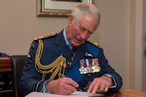 epa08005006 Prince Charles (R) sign the visitors book during a Queen&#039;s Colour Reception at RNZAF Base Whenuapai in Auckland, New Zealand, 18 November 2019. EPA/DAVID ROWLAND / POOL AUSTRALIA AND  ...