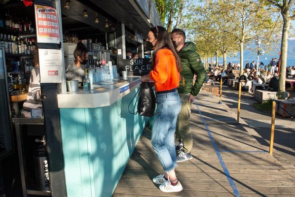 LAUSANNE, SWITZERLAND - MAY 03: People order directly at the booth of a restaurant during the coronavirus pandemic on May 3, 2021 in Lausanne, Switzerland. Switzerland has eased lockdown restrictions  ...