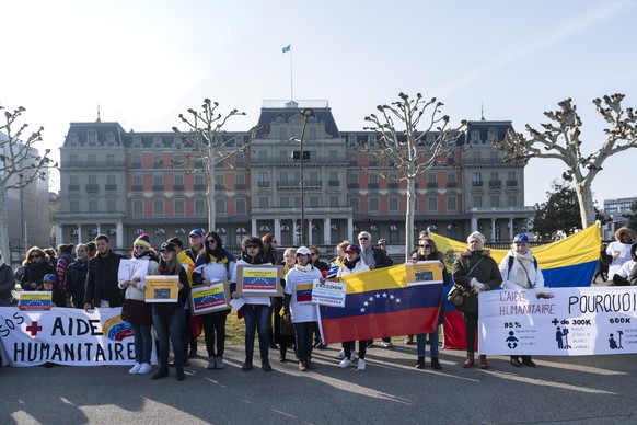 epa07390571 People demonstrate holding placards during a demonstration to support the entry of the humanitarian aid to Venezuela, in Palais Wilson in Geneva, Switzerland, 23 February 2019. Interim Pre ...