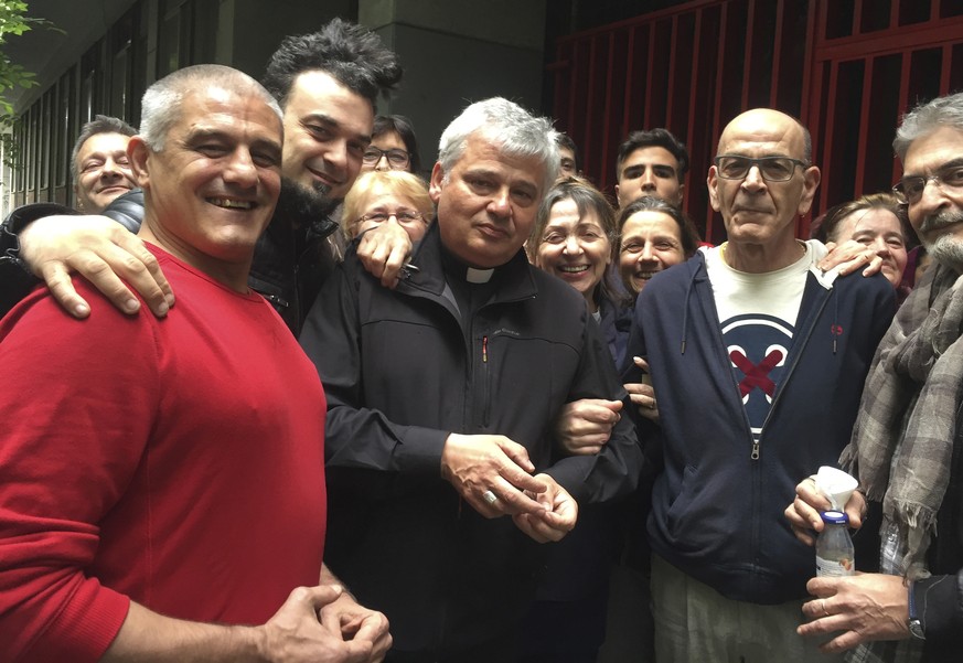 In this photo taken on Sunday, May 12, 2019, Cardinal Konrad Krajewski, center, poses with activists and residents of an unused state-owned building in Rome. Italian Interior Minister Matteo Salvini h ...