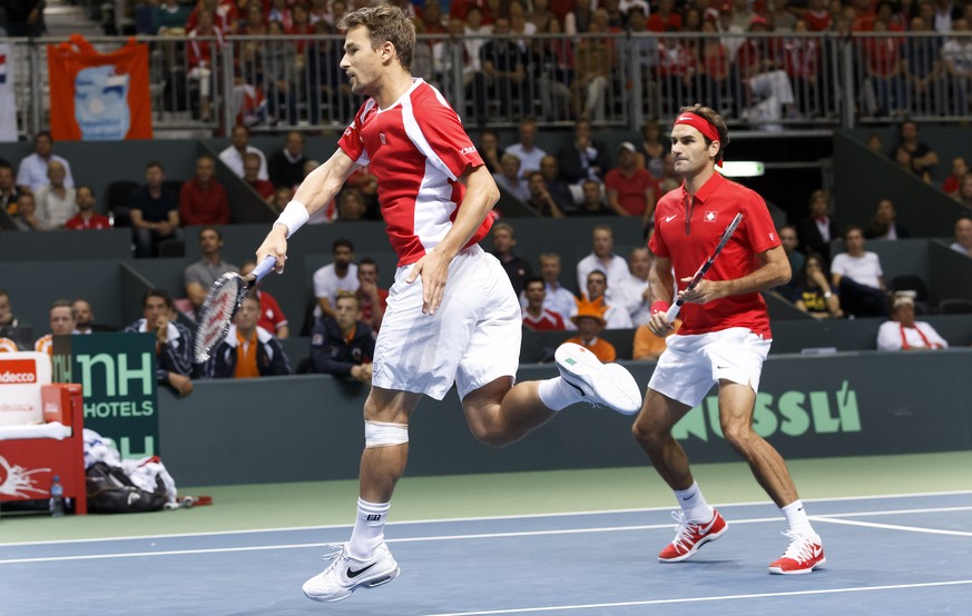Switzerland&#039;s Marco Chiudinelli, left, watched by his double partner, Roger Federer, right, returns the ball to Nertherlands&#039; Thiemo De Bakker, top left, and Matwe Middelkoop, top right, dur ...