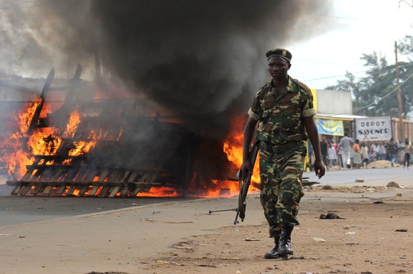 Ein Soldat läuft an brennenden Barrikaden vorbei: Der Protest gegen Nkurunzizas dritte Amtszeit&nbsp;wurde blutig niedergeschlagen.&nbsp;