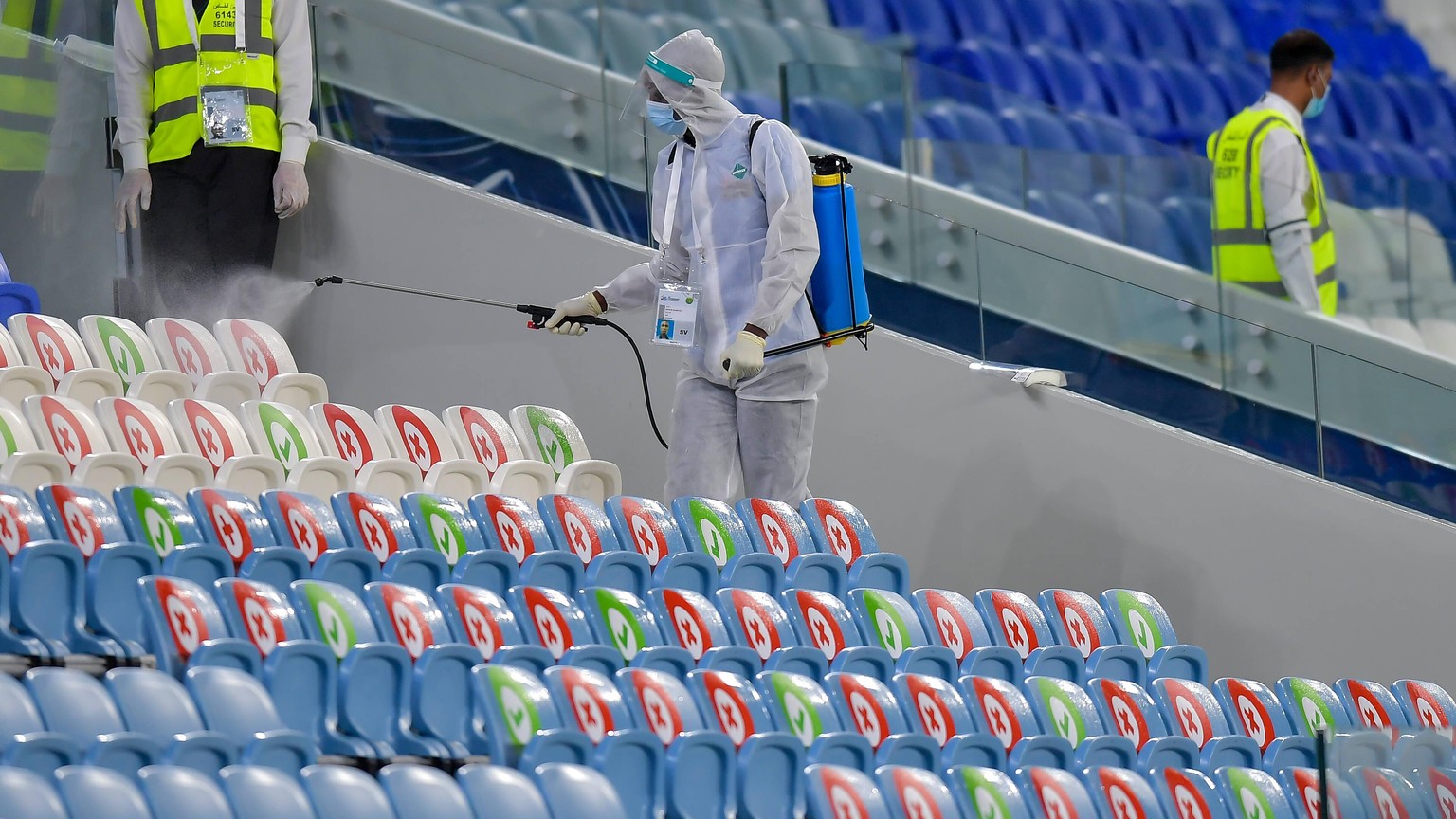 200918 -- DOHA, Sept. 18, 2020 -- An employee wearing personal protective equipment PPE disinfects the players bench inside Al-Janoub Stadium to prevent the spread of the COVID-19, prior to the 2020 A ...