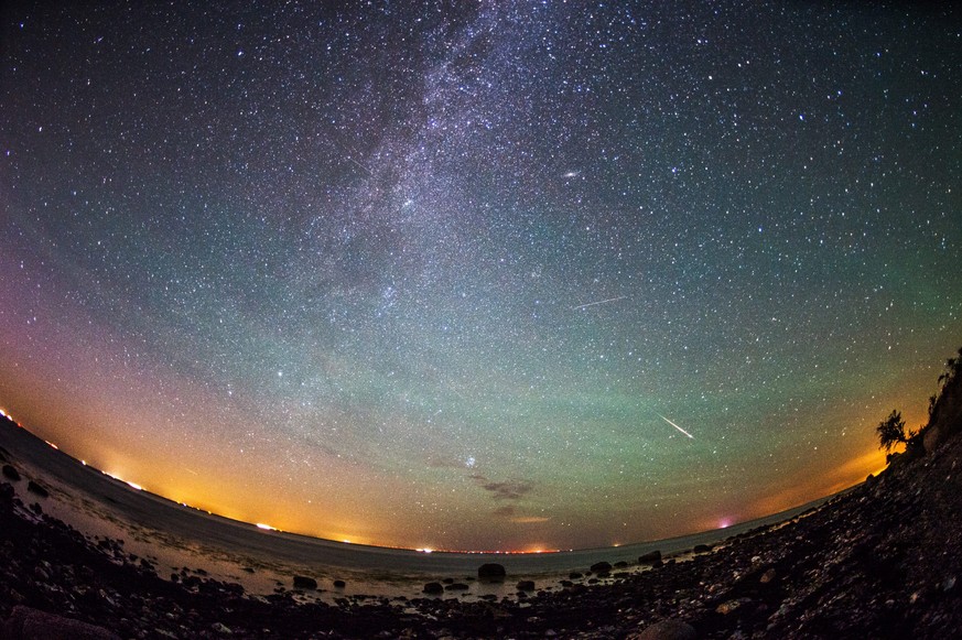 epaselect epa04881779 Meteors from the Perseid meteor swarm burn up in the atmosphere as our own galaxy, the Milky Way, is seen in the clear night sky over the German island of Fehmarn, Germany, early ...