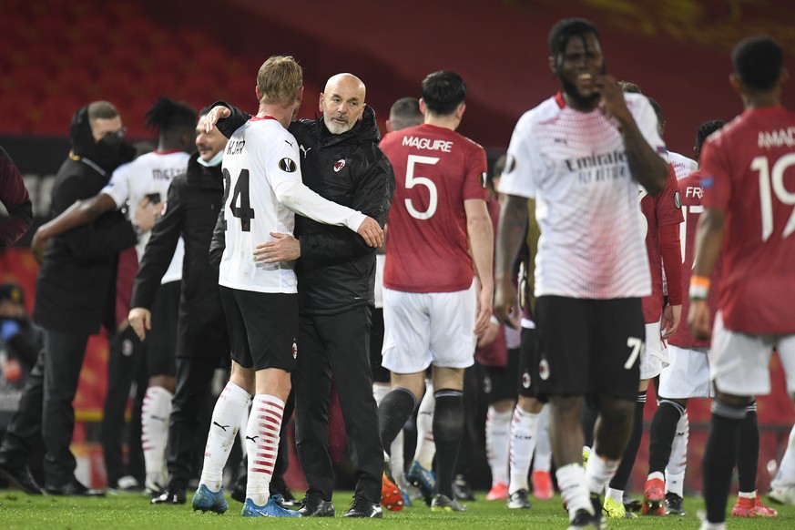 epa09068563 Milan&#039;s head coach Stefano Pioli (C) celebrates with Simon Kjaer (L) after the UEFA Europa League round of 16, first leg soccer match between Manchester United and AC Milan in Manches ...
