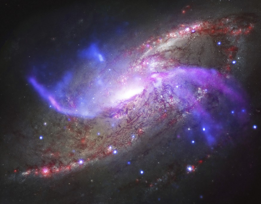 This composite image made available by NASA shows the galaxy NGC 4258, also known as M106, about 23 million light-years away from Earth. Two extra spiral arms glow in X-ray, optical, and radio light.  ...