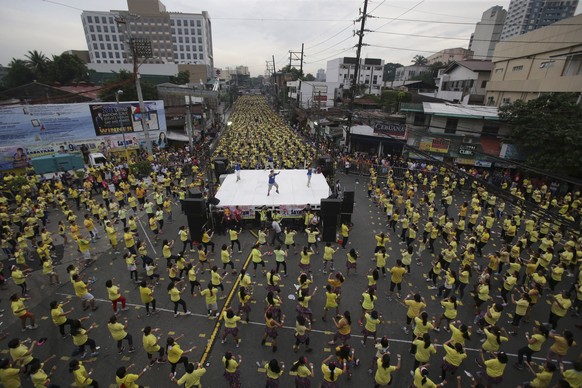 Filipinos follow an instructor on stage as they dance the Zumba during an attempt to break a Guinness world record in suburban Mandaluyong, east of Manila, Philippines on Sunday, July 19, 2015. Guinne ...