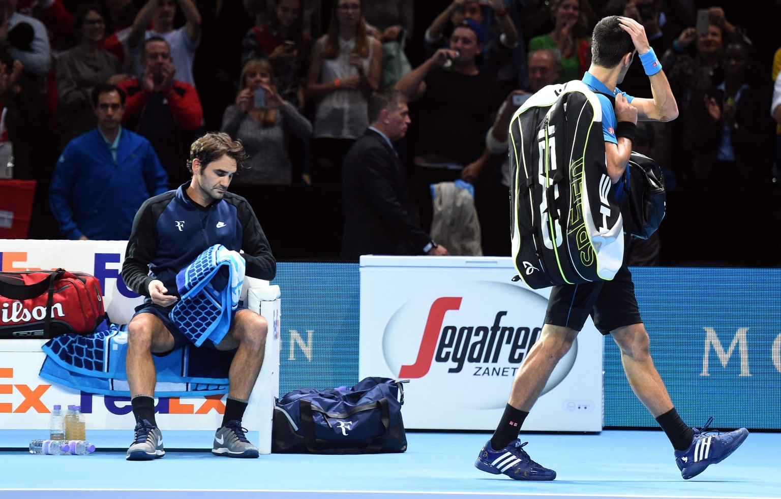 epa05030303 Serbia&#039;s Novak Djokovic (right) walks off the court after being defeated by Switzerland&#039;s Roger Federer (left) in their round robin game during the ATP World Tour Finals in Londo ...