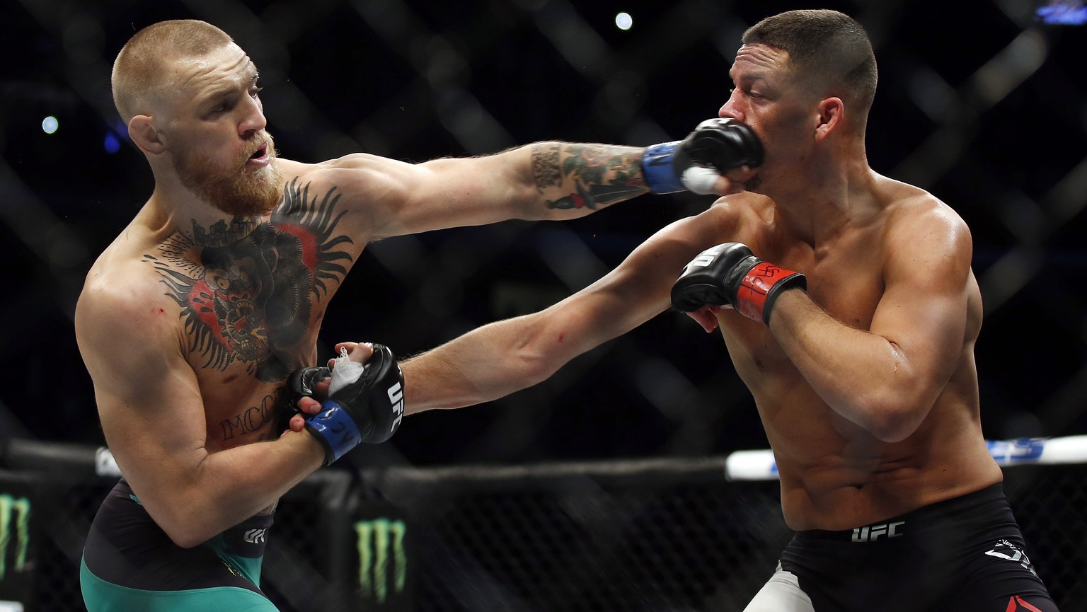 Conor McGregor, left, punches Nate Diaz during their welterweight mixed martial arts bout at UFC 202 on Saturday, Aug. 20, 2016, in Las Vegas. McGregor won by split decision. (AP Photo/Isaac Brekken)