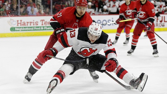 Carolina Hurricanes&#039; Nino Niederreiter (21), of the Czech Republic, and New Jersey Devils&#039; Nico Hischier (13), of Switzerland, chase the puck during the second period of an NHL hockey game i ...