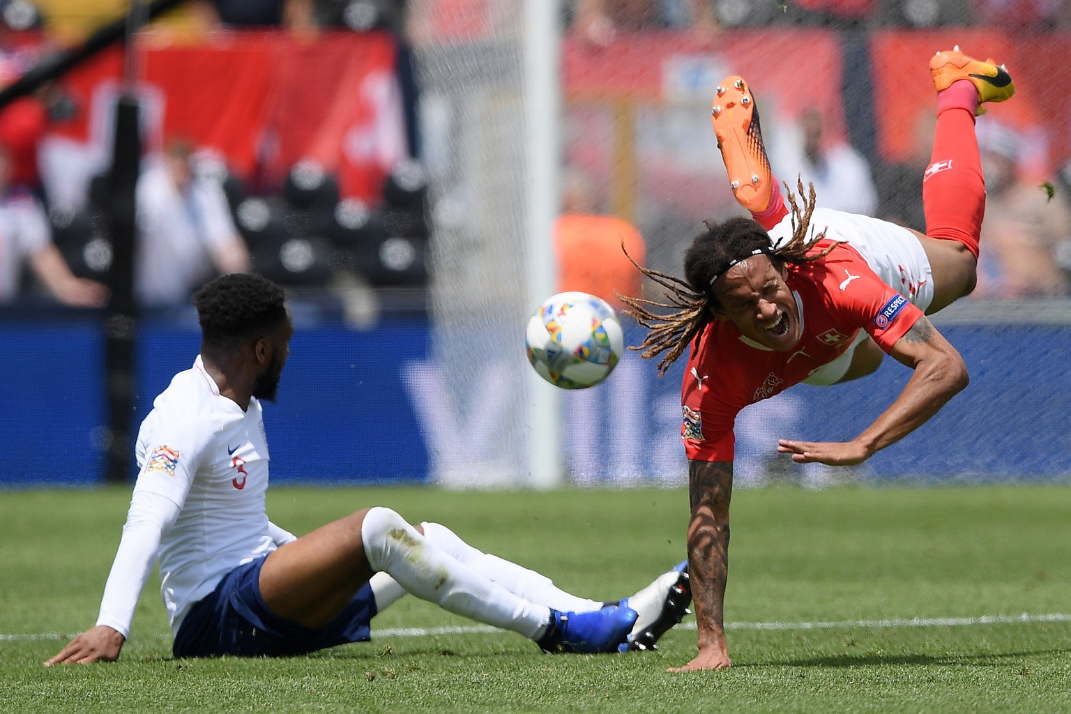epa07636982 Switzerland’s Kevin Mbabu (R) in action against England player Danny Rose during the UEFA Nations League third place soccer match between Switzerland and England in Guimaraes, Portugal, 09 ...