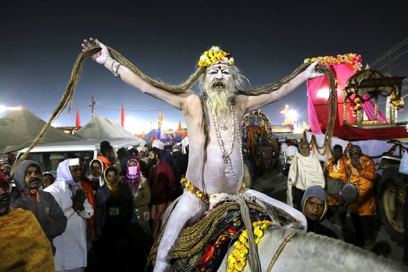 A naked Hindu holy man arrives on a horse back for ritualistic dip on auspicious Makar Sankranti day during the Kumbh Mela, or pitcher festival in Prayagraj, Uttar Pradesh state, India, Tuesday, Jan.1 ...