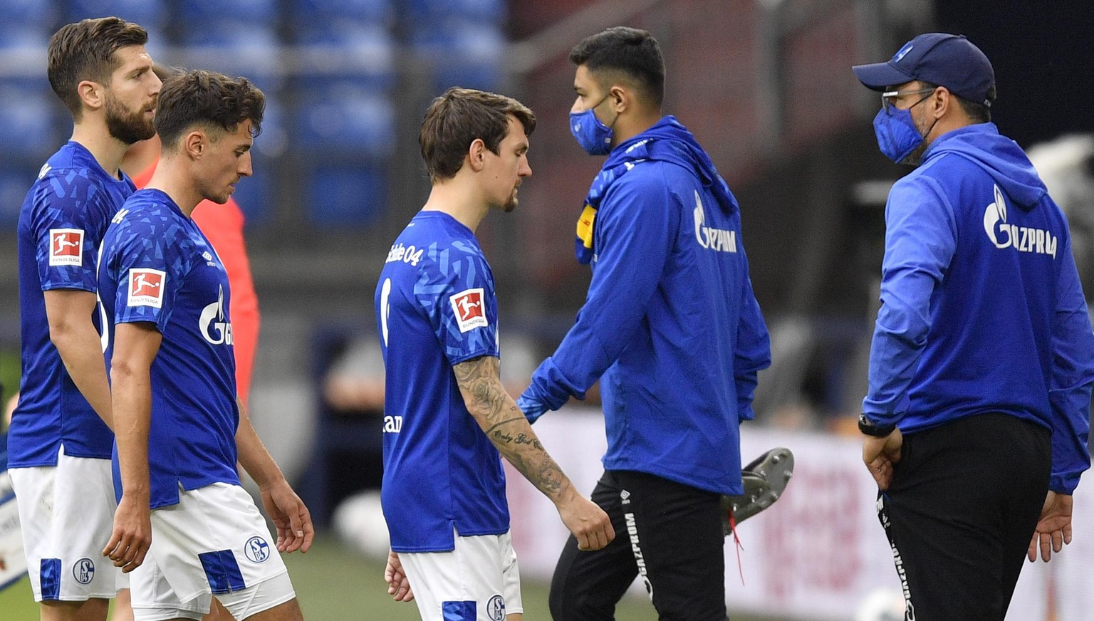 epa08441374 Schalke players leave the pitch at the end of the German Bundesliga soccer match between FC Schalke 04 and FC Augsburg in Gelsenkirchen, Germany, 24 May 2020. The German Bundesliga becomes ...