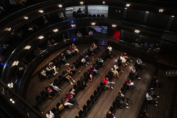 Spectators, wearing protective face masks and keeping social distance, watch the theatre play &quot;Jonathan&quot; at the KVS theatre in Brussels, Wednesday, April 28, 2021. The play was performed to  ...