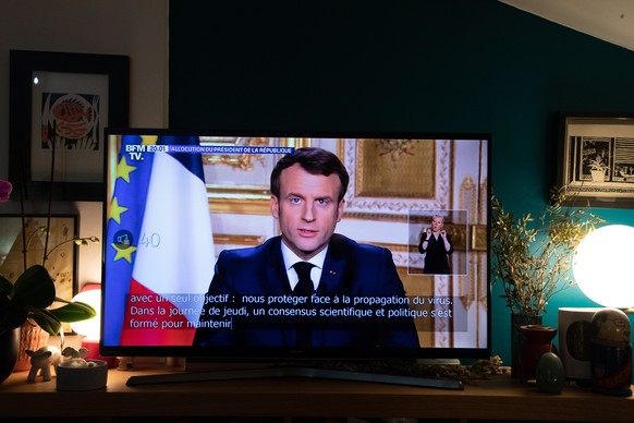 epa08299026 A TV screen shows French President Emmanuel Macron addressing the nation from the Elysee Palace about the widening coronavirus crisis, in Bois-Colombes, near Paris, France, 16 March 2020.  ...