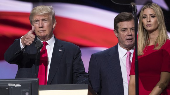 In this photo taken July 21, 2016, then-Trump Campaign manager Paul Manafort stands between the then-Republican presidential candidate Donald Trump and his daughter Ivanka Trump during a walk through  ...