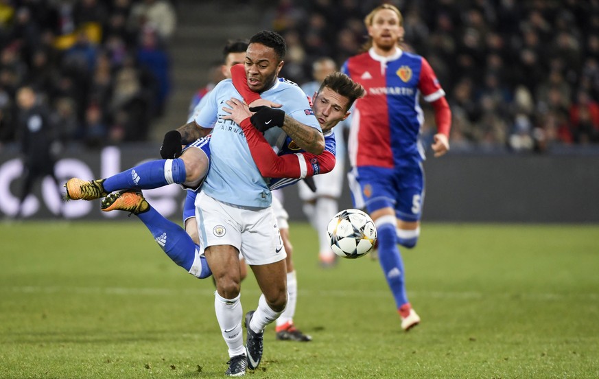 Basel&#039;s Taulant Xhaka, behind, clings to Manchester City&#039;s Raheem Sterling, front, and will get the yellow card for this action, during the UEFA Champions League round of sixteen first leg s ...