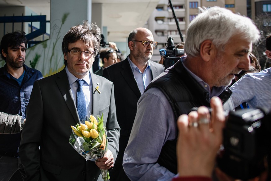 epa06651981 Former Catalan leader Carles Puigdemont (2-L) walks with flowers in his hands next to Josep Maria Matamala (R), a businessman and confidant of former Catalan leader Carles Puigdemont, afte ...