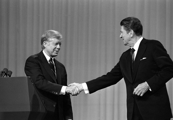 ADVANCE FOR MONDAY, SEPT. 5 AND THEREAFTER -FILE - In this Oct. 28, 1980 file photo, President Jimmy Carter shakes hands with Republican Presidential candidate Ronald Reagan after debating in the Clev ...