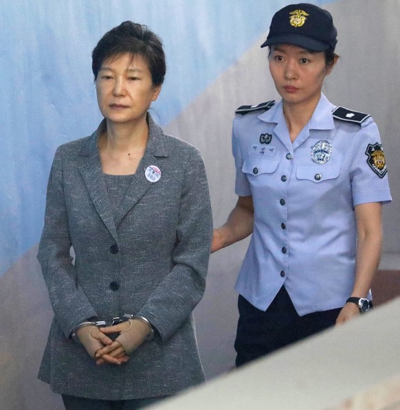 epa06161274 South Korean Former President Park Geun-hye (C) is escorted to a courtroom in Seoul, South Korea, 25 August 2017, to stand trial on alleged bribery, abuse of power and leaks of government  ...