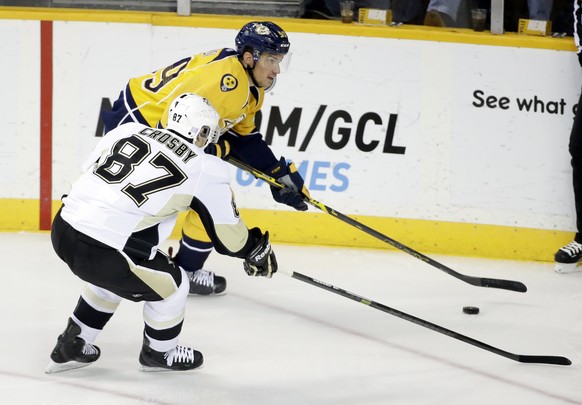 Nashville Predators defenseman Roman Josi (59), of Switzerland, chases down the puck with Pittsburgh Penguins center Sidney Crosby (87) in the first period of an NHL hockey game Saturday, Oct. 25, 201 ...