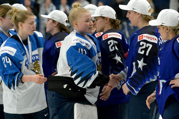 Goalkeeper Noora R&#039;ty (41) of Finland followed by Noora Tulus (24) congratulates US players for their 2-1 shootout victory after the IIHF Women&#039;s Ice Hockey World Championships final match b ...