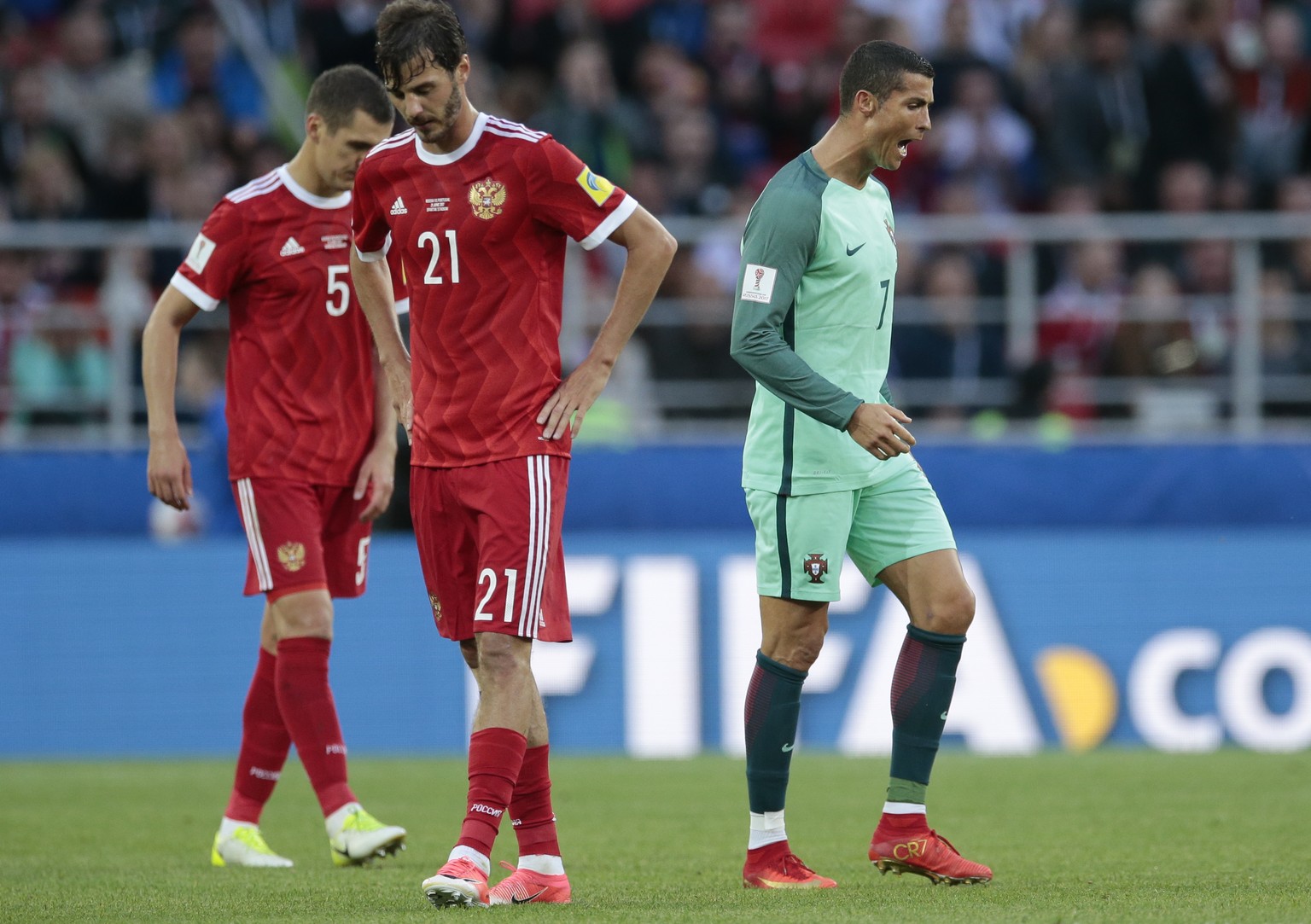 Portugal&#039;s Cristiano Ronaldo, right, celebrates past Russia&#039;s Viktor Vasin, left, and Aleksandr Erokhin his side&#039;s 1-0 win, at the end of the Confederations Cup, Group A soccer match be ...