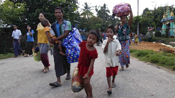 epa05584141 Rakhine ethnics who fled from fighting area carry their belongings as they arrive to take refuge at Boothee Taung town, Rakhine State, western Myanmar, 13 October 2016. Fightings continue  ...