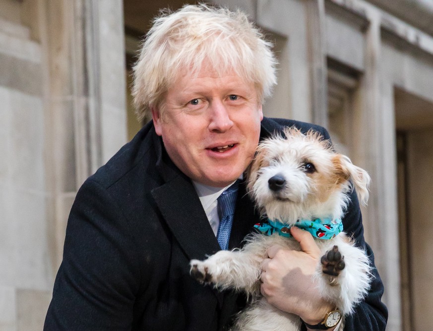 epaselect epa08064553 Britain&#039;s Prime Minster Boris Johnson leaves the polling station after casting his vote with his dog Dylan, during the general election in London, Britain, 12 December 2019. ...