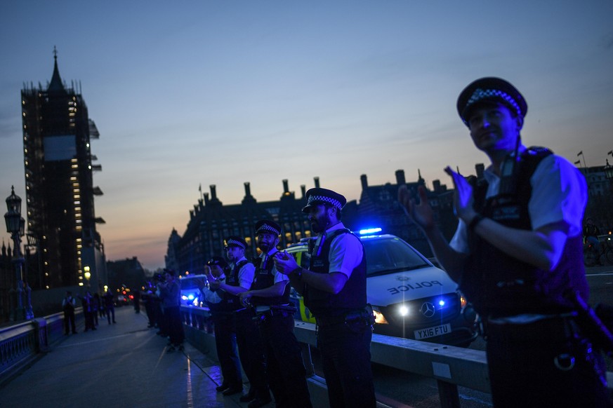 LONDON, ENGLAND - APRIL 09: Police officers are seen applauding NHS staff and key workers on Westminster Bridge on April 09, 2020 in London, England. Following the success of the &quot;Clap for Our Ca ...