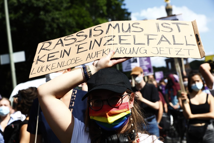 epa08553633 A demonstrator holds up a banner reading &#039;Racism is not an isolated case&#039; during the &#039;Solidarity knows no summer break&#039; protest event in Berlin, Germany, 18 July 2020.  ...