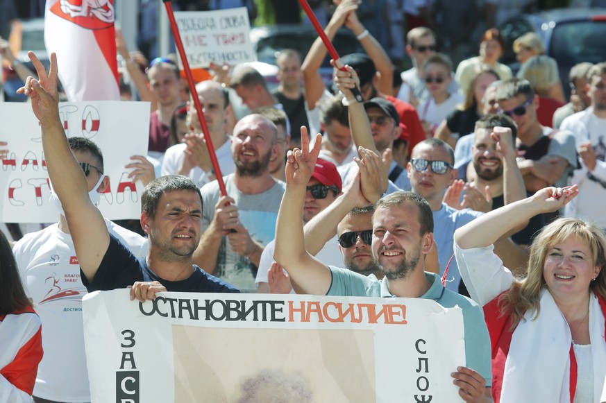 People hold a banner reading &quot;Stop violence!&quot; during a rally near the Belarus Television headquarters in Minsk, Belarus, Monday, Aug. 17, 2020. Thousands of factory workers are taking to the ...