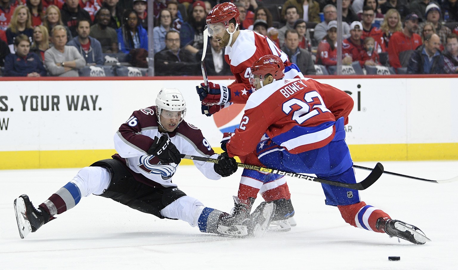 Colorado Avalanche right wing Mikko Rantanen (96), of Finland, fights for the puck against Washington Capitals defenseman Madison Bowey (22) and defenseman Brooks Orpik (44) during the first period of ...