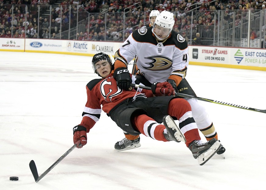 Anaheim Ducks defenseman Hampus Lindholm (47) checks New Jersey Devils center Nico Hischier (13) to the ice during the second period of an NHL hockey game Monday, Dec. 18, 2017, in Newark, N.J. Lindho ...