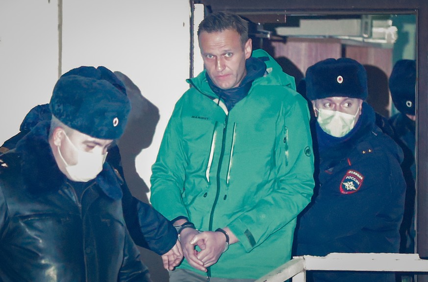 epa08946490 Russian opposition leader and anti-corruption activist Alexei Navalny (C) is escorted out of a police station in Khimki outside Moscow, Russia 18 January 2021. A Moscow judge on 18 January ...