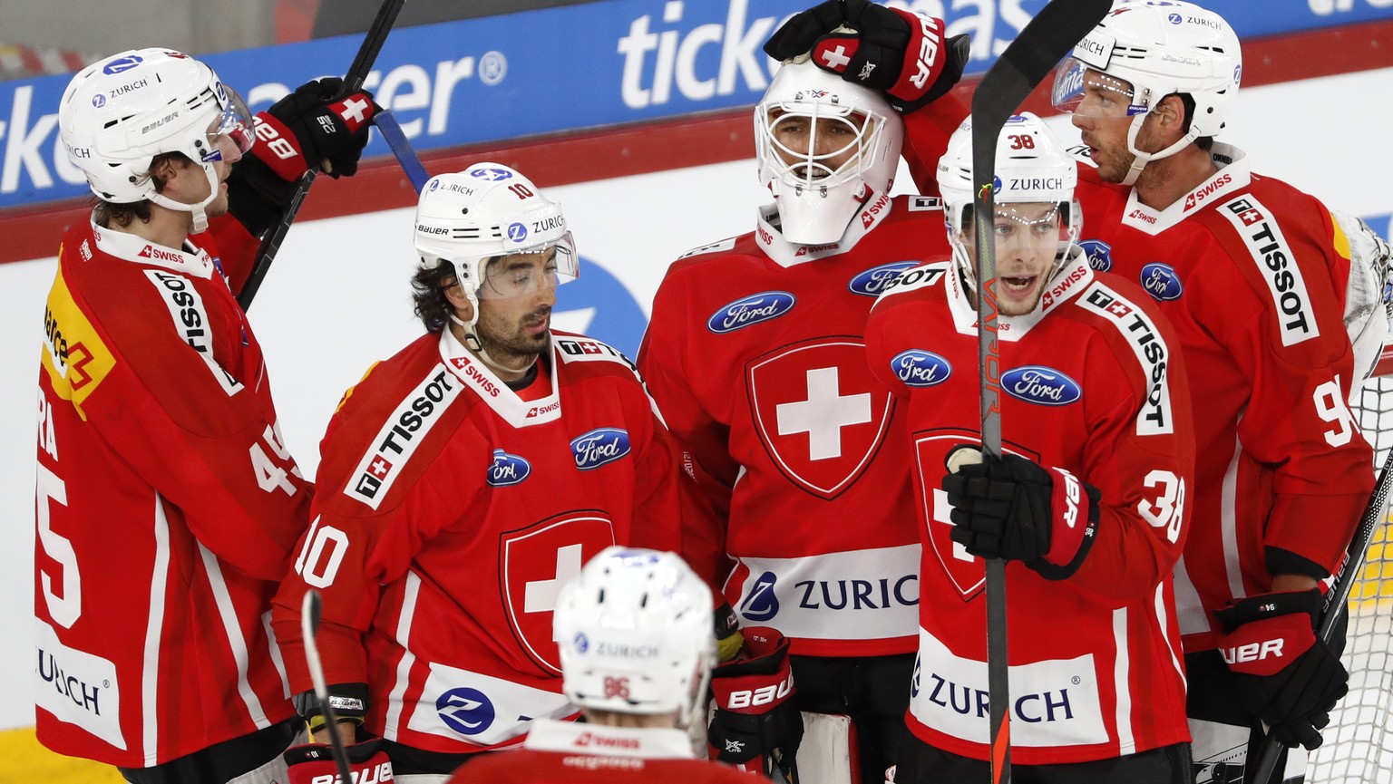 Switzerland&#039;s goalkeeper Joren van Pottleberghe, center, celebrates with his teammates Michael Fora, Andres Ambuehl, Lukas Frick and Samuel Walser, from left, at the end of a friendly ice hockey  ...