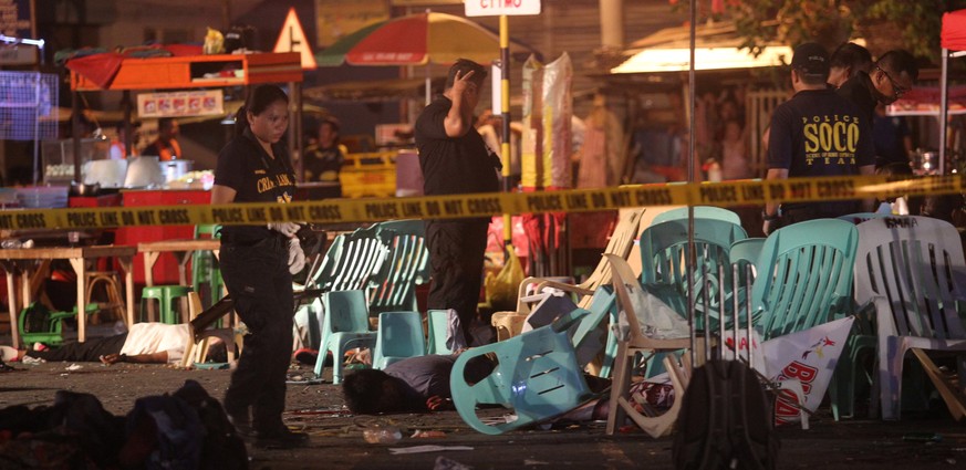 ATTENTION EDITORS - VISUALS COVERAGE OF SCENES OF DEATH OR INJURY Bodies lie on the ground while police investigators inspect the area of a market where an explosion happened in Davao City, Philippine ...