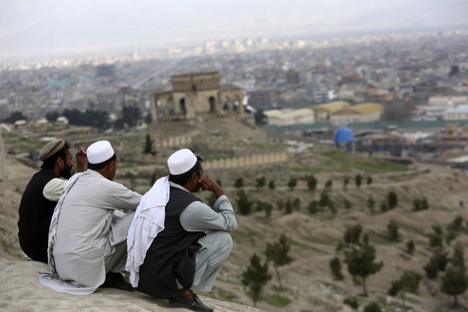 In this March 27, 2017, file photo, men sit on the Nadir Khan hilltop overlooking Kabul, Afghanistan. As America’s 16-year war in Afghanistan drags on, Russia is resurrecting its own interest in the “ ...