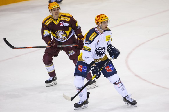 Geneve-Servette&#039;s forward Tommy Wingels, of USA, left, and Ambri-Piotta&#039;s defender Michael Fora, right, look the puck, during a National League regular season game of the Swiss Championship  ...