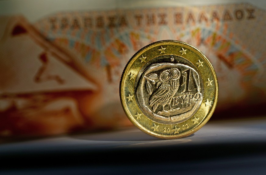 epa04624069 A close-up of a euro coin from Greece in front of a 100 drachma banknote in Potsdam, Germany, 17 February 2015. Greece rejected a European demand on 16 February to request an extension of  ...
